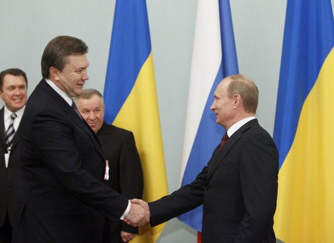 Янукович и Путин жмут руки друг другу