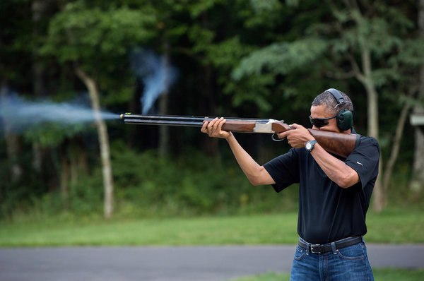 Обама стреляет из оружия.